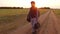 Boy teen traveling. Boy teenage tramp walking along the road in a hood with backpacks a sad traveler
