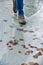 Boy teenager in boots jumps, runs through the puddles in the cold autumn