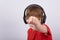 Boy teenager with headphones shows his fist. Child listens to music with headphones