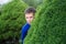 Boy teenager peeking out of a bush