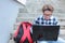 Boy teenager schoolboy or student is sitting on the stairs, working in the computer, wearing glasses, in a shirt, smiling, red b