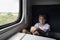 Boy teenager sits in compartment carriage. Traveling by train with children. Travel by railway