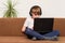 Boy teenager sitting on couch with laptop in hand and stereo headphones. Computer games addiction concept