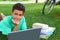 Boy teenager studying laying green grass garden