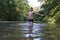 Boy teenager swims in river in summer