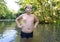 Boy teenager swims in river in summer