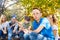 Boy and teens sit on campsite with sausages