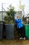 Boy throw Christmas tree in the garbage bin and close cover