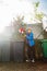 Boy throw Christmas tree in the garbage bin on with Santa hat