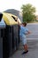 Boy throws a plastic bottle into the yellow container for recycling