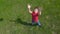 Boy throws up the ball, standing on green lawn