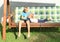 Boy tickling girl on a wooden swing