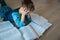 Boy tired of reading, kid stressed by doing homework