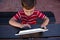 Boy touching digital tablet while sitting at table in school