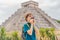 Boy traveler, tourists observing the old pyramid and temple of the castle of the Mayan architecture known as Chichen