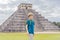 Boy traveler, tourists observing the old pyramid and temple of the castle of the Mayan architecture known as Chichen