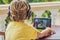 Boy in tropics talking with friends and family on video call using a tablet and wireless headphones