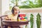 Boy in tropics talking with friends and family on video call using a tablet and wireless headphones