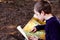 Boy trying to read an old travel map  lost in a forest  in search of adventure