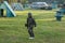 Boy in uniform with paintball gun and helmet on the field. Sport, active lifestyle