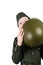 Boy in uniform, peeking out from behind a green helmet, isolated on white