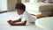 Boy use mobile phone to play game on floor. Mixed afro child read e book or watch video