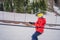 Boy uses a training lift. Child skiing in mountains. Active toddler kid with safety helmet, goggles and poles. Ski race