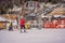 Boy uses a training lift. Child skiing in mountains. Active toddler kid with safety helmet, goggles and poles. Ski race