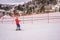 Boy uses a training lift. Child skiing in mountains. Active toddler kid with safety helmet, goggles and poles. Ski race