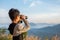 Boy using binocular to watch mist in forest