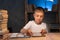 Boy using digital tablet while sitting on desk at home at night. Reading and studying