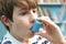 Boy Using Inhaler To Treat Asthma Attack