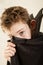 Boy in vampire cloak covering part of face