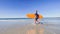 Boy walk holding orange surfboard at sand ocean beach