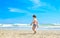 A boy is walking on the seashore. A child on a tropical beach. Sand and water are fun, sun protection for young children.