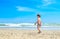 A boy is walking on the seashore. A child on a tropical beach. Sand and water are fun, sun protection for young children.