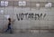 A boy walks in front of a graffiti that says we will vote in Barcelona