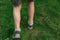 Boy walks through the grass. Feet on the background lawn