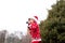 A boy in a warm Christmas sweater with a New Year`s deer and a Santa hat conducts a workout boxing sparky in the fresh air