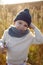 boy in warm clothes stand on chair along a path on a field with dried grass