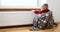 Boy warm one\'s hands near radiator at home.