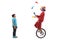 Boy watching a clown juggling and riding a unicycle