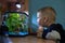 Boy is watching fish tank in his room