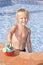 Boy with watering can in the swimming pool