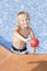 Boy with watering can in the swimming pool