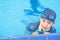 Boy wearing goggles on the edge of the pool. Summer children`s sports activity with a parent. Learning and relaxation concept.
