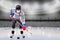 Boy Wearing Mask Practicing Hockey Skills at Empty Ice Rink During COVID-19 Pandemic