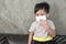 A boy wearing medical face mask for pollution or coronavirus,child itchy eyes and nose.