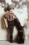 Boy wearing vintage puts leg on suitcase, retro shot, 50s-60s