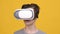 Boy Wearing VR Headset Experiencing Virtual Reality, Yellow Background